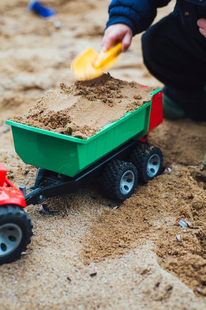 Green and Black Utility Trailer on Brown Sand